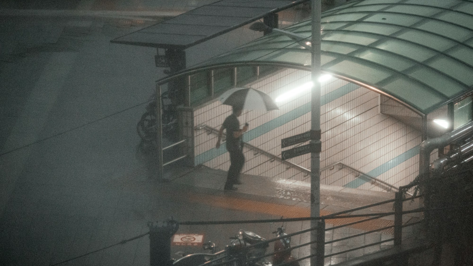 Rainy city street near a subway entrance